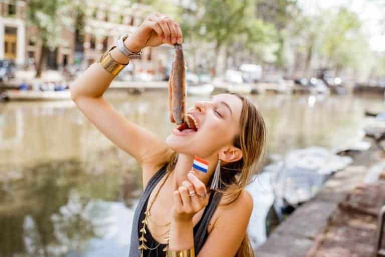 Girl eating herring Woman eating herring in Amsterdam