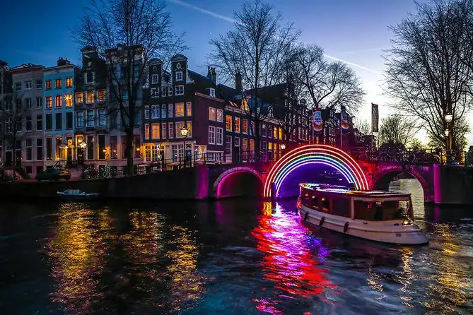 Salonboot dat onder een lichtgevende boog vaart in Amsterdam