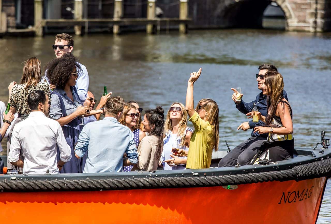Groep mensen die feesten op een sloep in Amsterdam