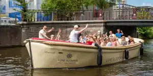 Mensen die terugzwaaien op een luxe sloep in Haarlem