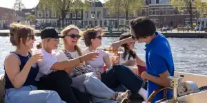 Schipper schenkt wijn in op een luxe sloep in Haarlem