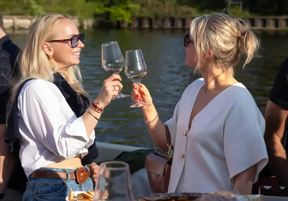 2 vrouwen die hun wijn proosten op een luxe sloep in Haarlem
