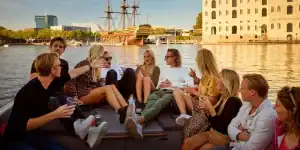 Lachende groep mensen in sloep amsterdam