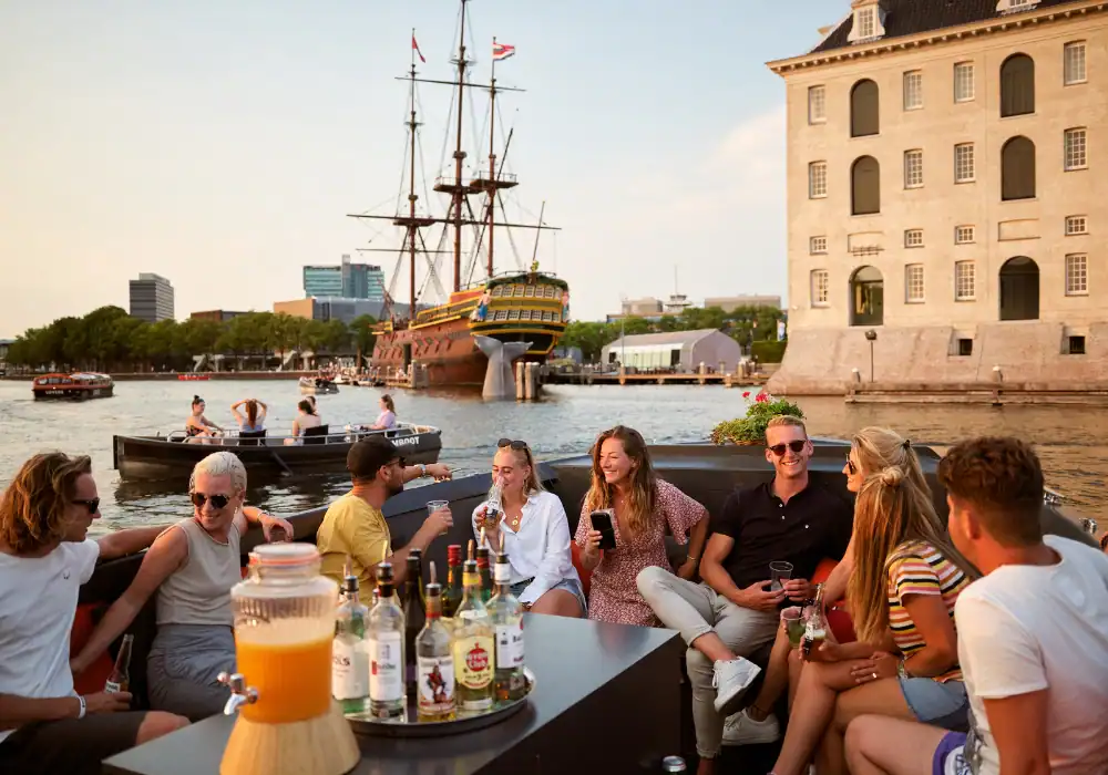 Gruppe von Menschen die auf einer Schaluppe Drinks genießen