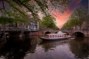 Bartolotti salonboot bij zonsondergang op de Amsterdamse grachten