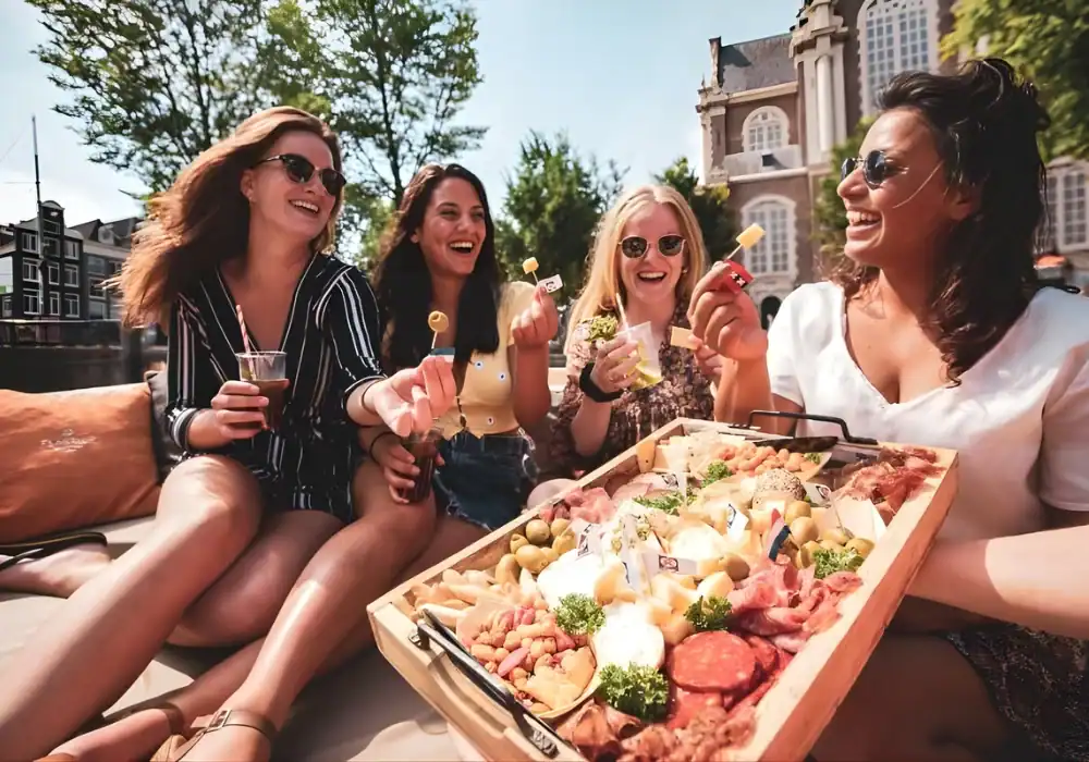 4 dames die van een borrelplank eten op een boot in Amsterdam