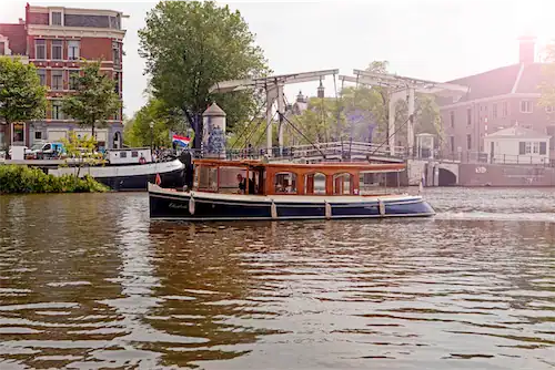 Saloon boat Elisabeth sailing through Amsterdam canals