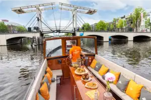 Schipper varend op Bartolotti boot onder brug Amsterdamse grachten