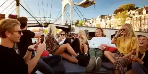 Groep mensen op varende sloep in Amsterdam