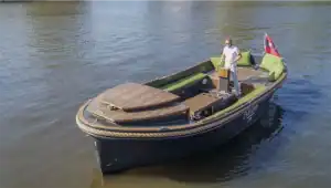 Sloep naut varend op grachten met schipper