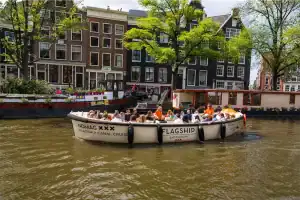 Sloep nomag met schipper en groep op grachten Amsterdam