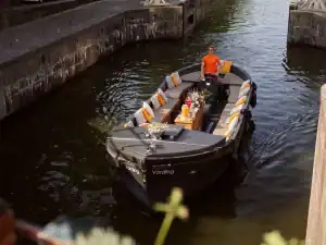 Sloep vording varend met schipper op grachten
