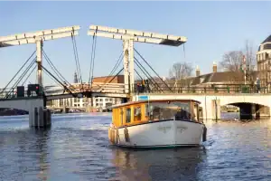 Vooraanzicht Saloonsloep voor brug Amsterdam