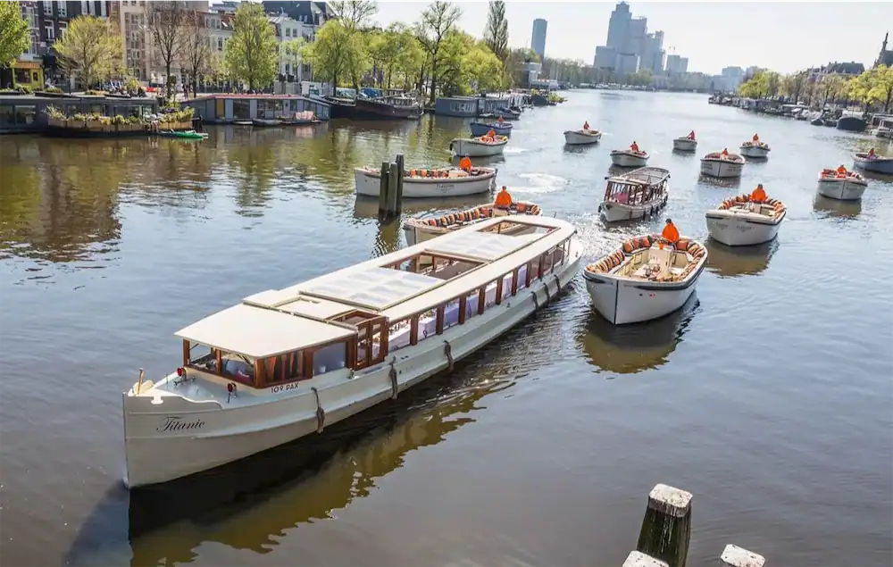 Salon boat Titanic sailing with other sloops on the Amsterdam canals
