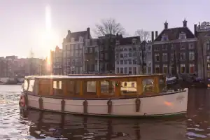 Zijaanzicht van Saloonsloep Amsterdam varend over de grachten