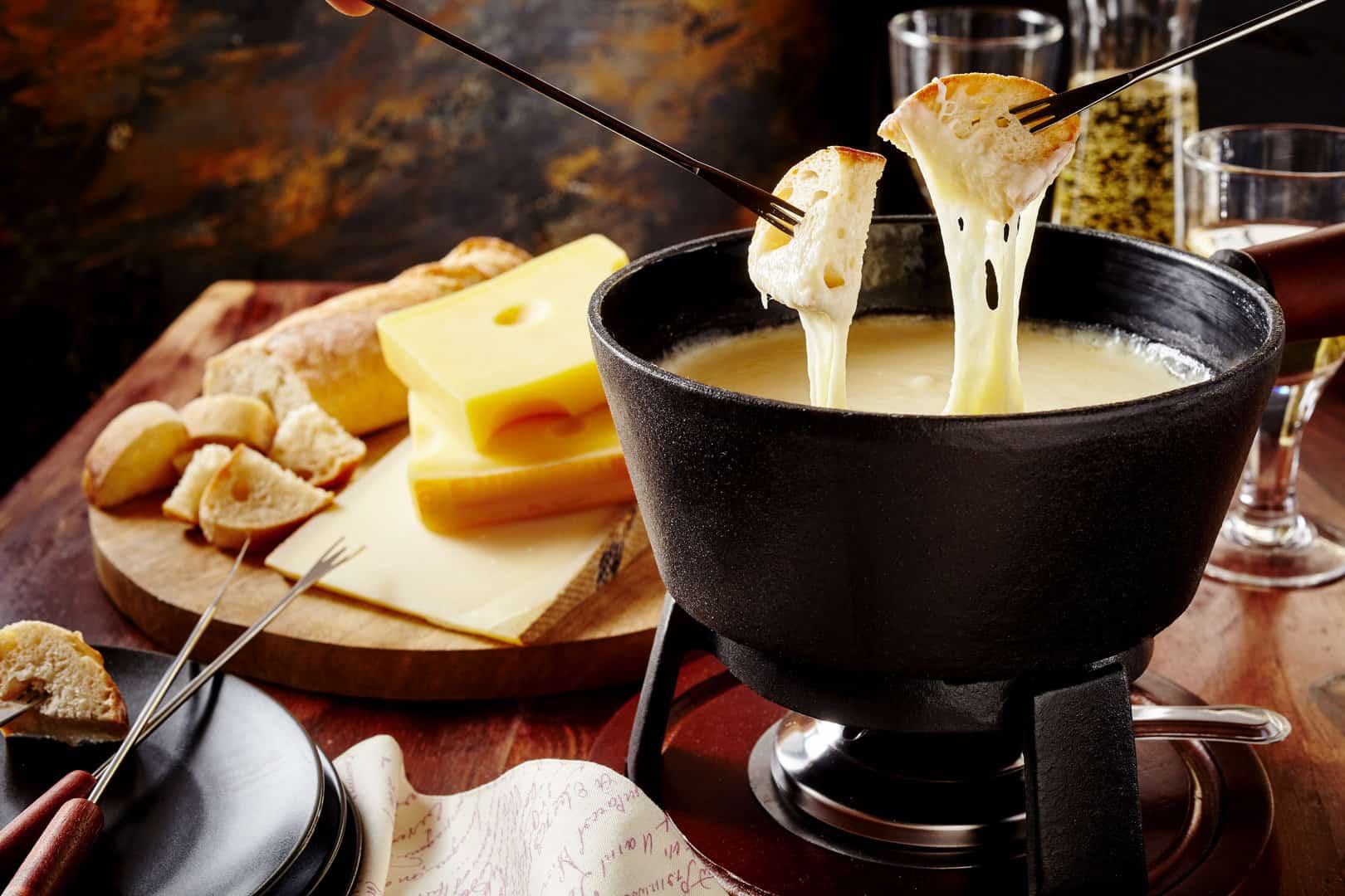 Brot wird in ein Käsefondue getaucht